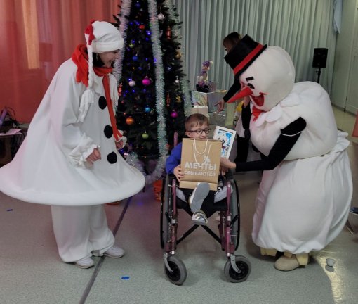 фото людей в костюмах снеговиков поздравляющих ребёнка на инвалидной коляске