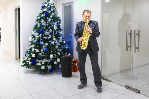 фото саксофониста на фоне новогодней ёлки